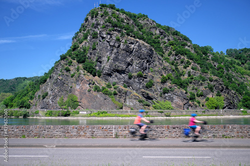 Radfahrer auf Radweg am Rhein entlang an der Loreley bei sonnigem Wetter - Stockfoto