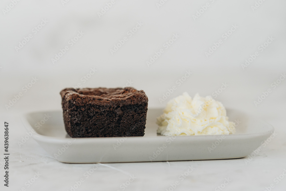 Brownie with whipped cream on a plate