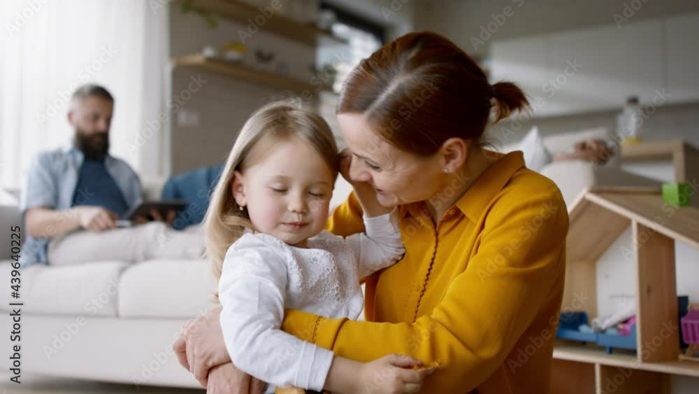 Happy family at home, father working, mother playing with daughter. Happy family at home, father working, mother playing with daughter.