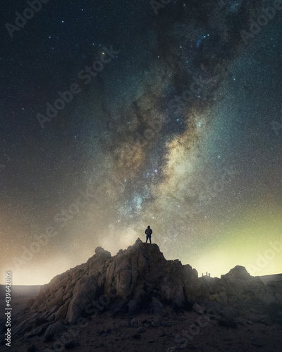 unknown persona standing on the top of the mountain with view to Milky Way