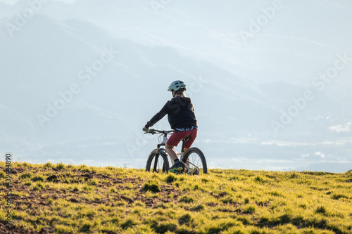 Girl child riding mountain bike at sunset. Beautiful golden summer light.