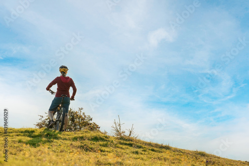 Woman on mountain bike looking at sunset in nature