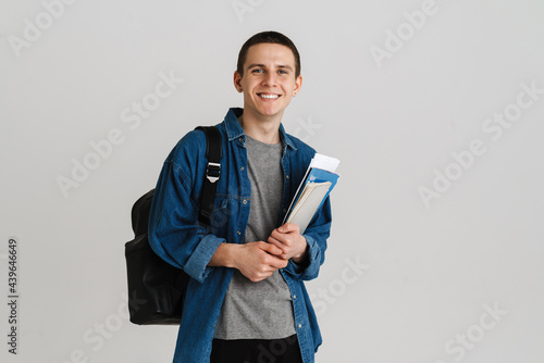 Photo Young brunette student man smiling while holding exercise books