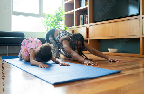 Mother and daughter exercising together at home.