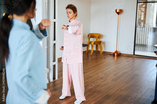 Two women in pink and blue practicing Chinese martial art
