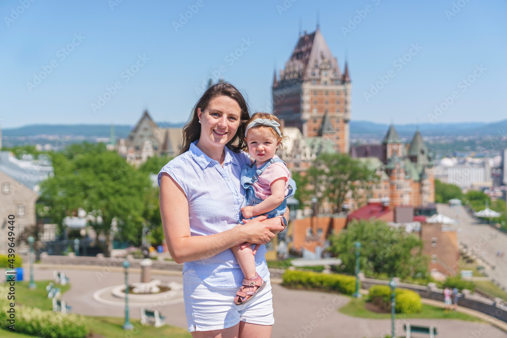 women with baby at the blurred Frontenac Castle in the background