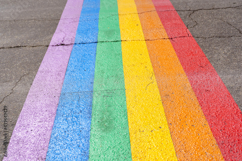 Gay pride flag crosswalk on the road of a city