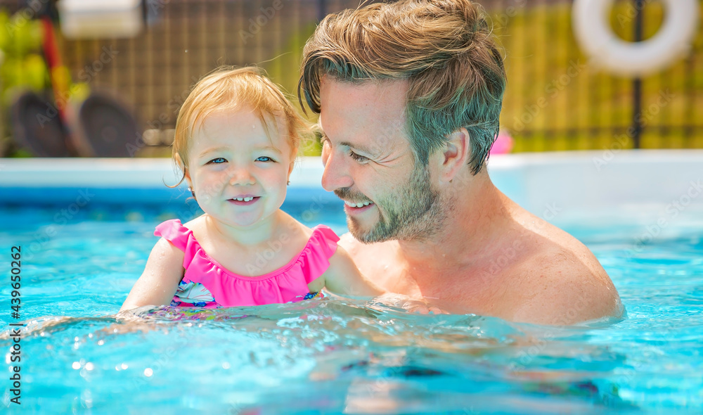 father with the child girl in the pool