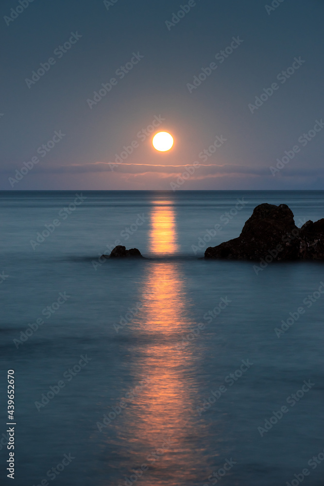 Long exposure on the coast with a full moon.