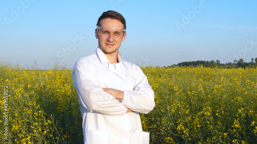 A plant specialist, checking the field soy, in a white coat makes a test analysis in a tablet, a background of greenery. Concept ecology, bio product, inspection, water, natural products, professional