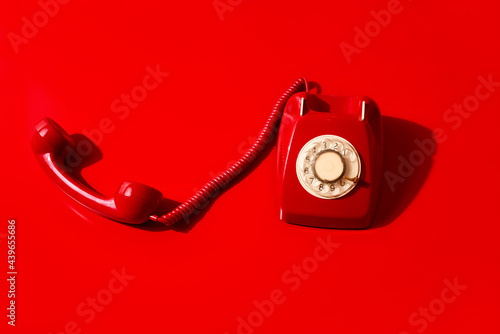 red rotary dial telephone off the hook