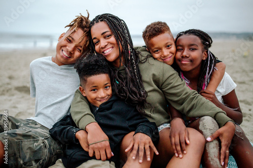 Happy Black family cuddled together at beach photo
