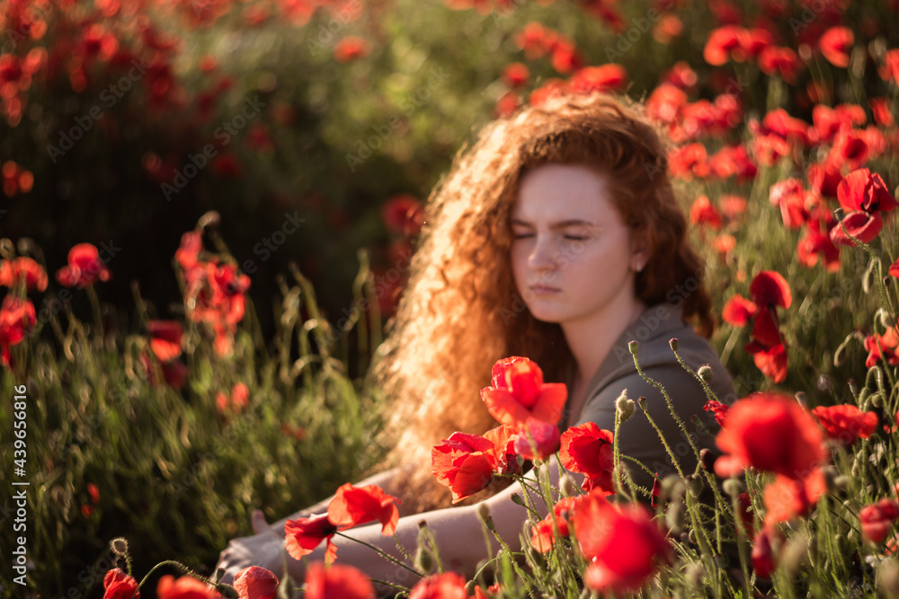Young beautiful red-hear girl in red poppy field Young beautiful red-hear girl in red poppy field