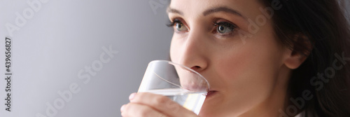 Canvas Print Young brunette woman drinking water from glass