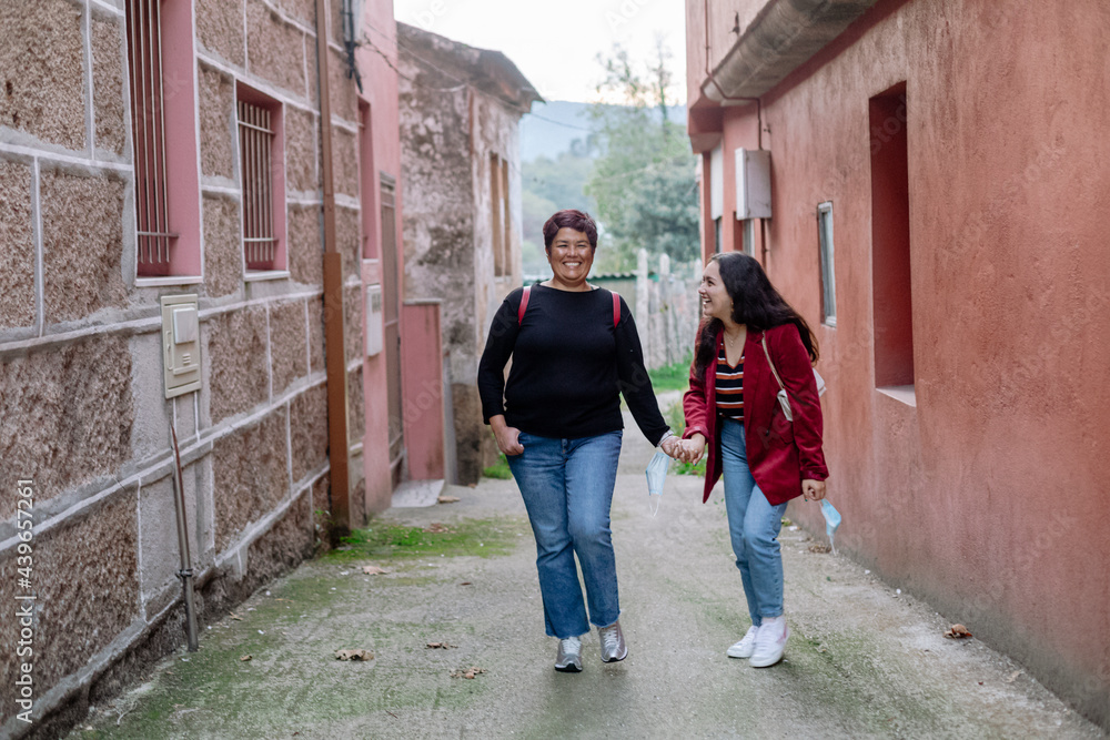 Mother and daughter smiling while holding hands Mother and daughter smiling while holding hands