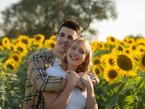 Cuadro en lienzo Pareja joven disfrutando de sus vacaciones en un campo de girasoles durante la p
