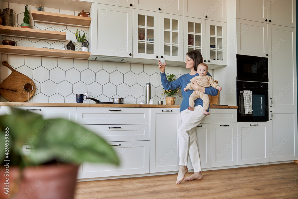 Mother watching cup with water to prepare milk