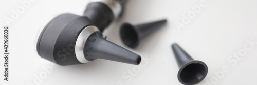 Closeup of otorhinolaryngologist otoscope tool on white background photo