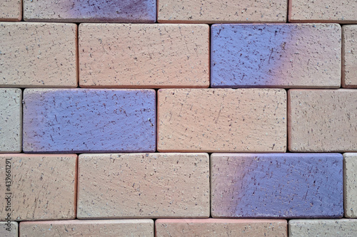 Texture of multicolored painted blue and sand bricks photo