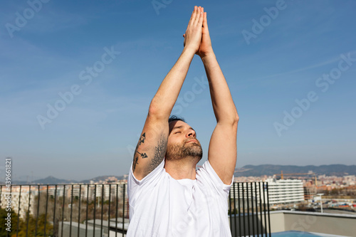 man practicing yoga on rooftop photo