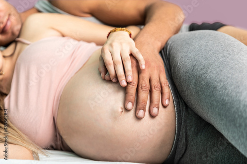 Pregnat couple in the bedroom.