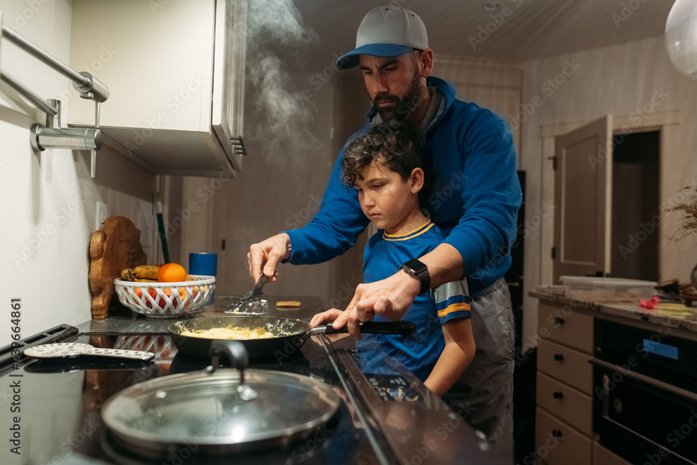 Father and son cooking together. Father and son cooking together.