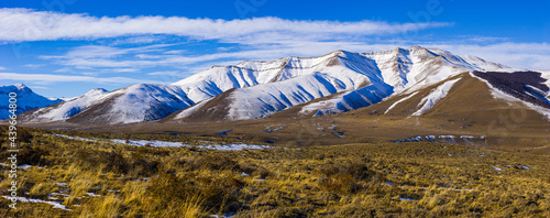 Winter landscape in Patagonia: snow covered hills rising from the pampas