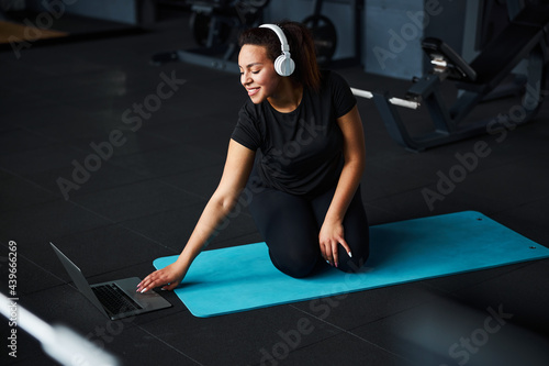 Happy woman starting training with notebook in gym