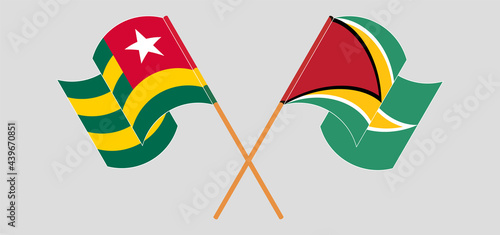 Crossed and waving flags of Togo and Guyana