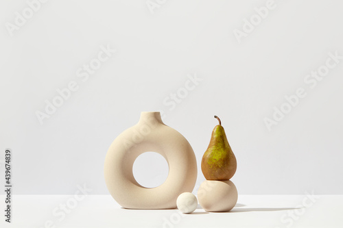 Still life with ceramic vase and pear photo