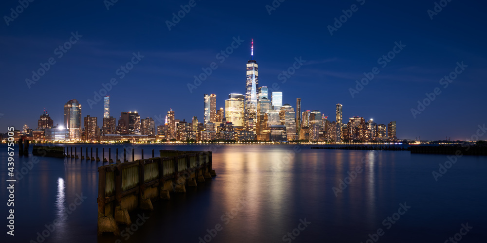 The skyscrapers of the Financial District in Lower Manhattan of New York city at Dusk. Reflection upon Hudson River of World Trade Center buildings, NYC, USA