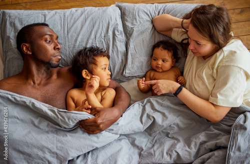 Happy family woke up at home on a bed