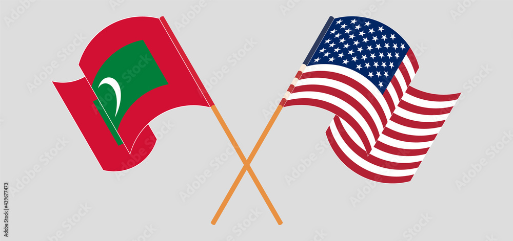 Crossed and waving flags of Maldives and the USA