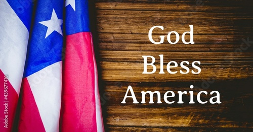 Картината върху платно Composition of text god bless america with american flag on wood background
