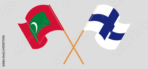 Crossed and waving flags of Maldives and Finland