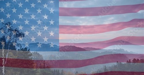 Composition of billowing american flag over mountain landscape and cloudy blue sky