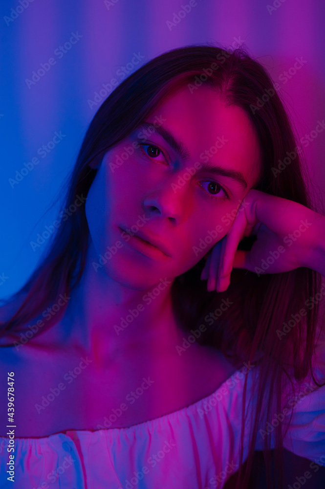 Androgynous man touching hair and looking at camera Androgynous man touching hair and looking at camera