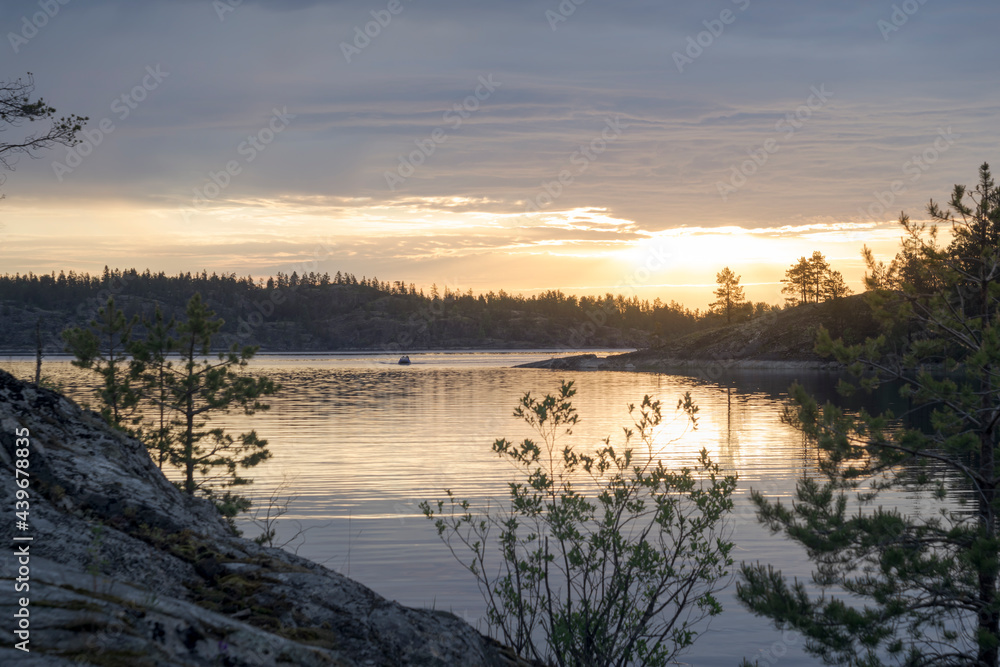 Inflatable boat with a motor on a lake at sunrise. Tourism on a islands of Lake Ladoga.