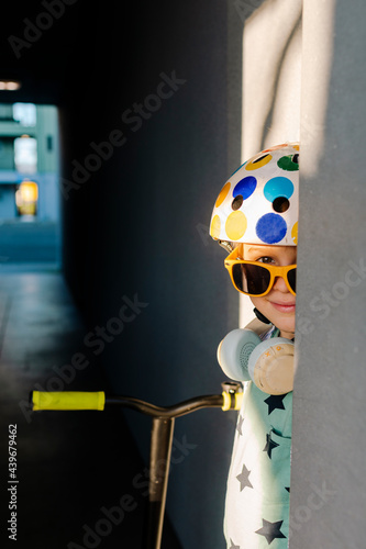 Boy wearing helmet and sunglasss hidding in hallway photo