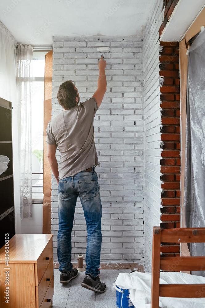 Unrecognizable Man painting wall at home Unrecognizable Man painting wall at home