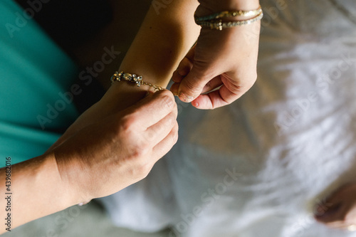 bride getting help putting bracelet on  photo
