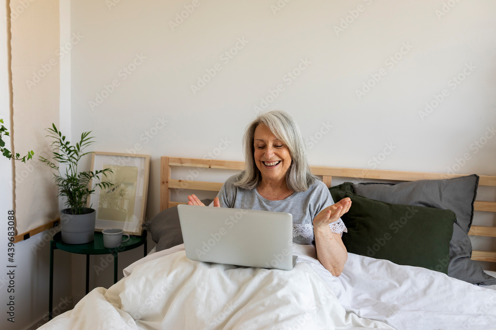 mature woman having a video call in bed mature woman having a video call in bed