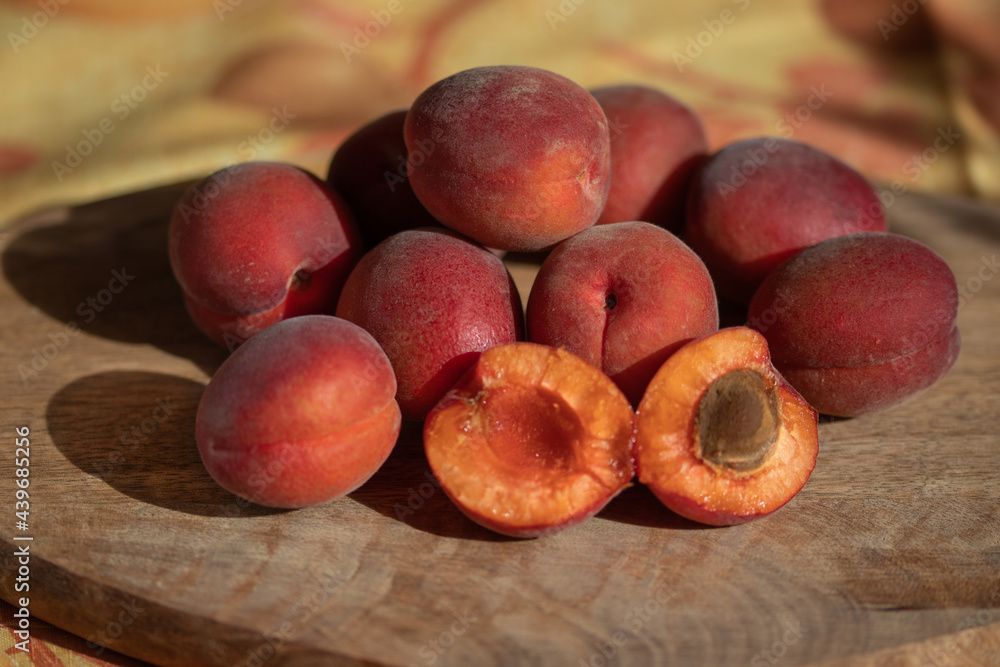 Fototapeta premium Red apricots on a wooden table