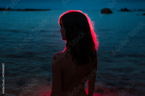 Black and red girl silhouette standing in a beach photo