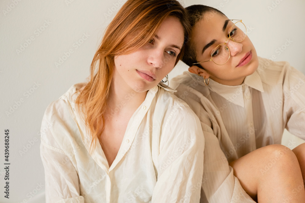 Two Women In Cream Tones Outfits Lean On Each Other Two Women In Cream Tones Outfits Lean On Each Other