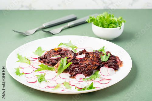 An alternative to meat protein is beet steak with vegetables and herbs on a plate. Flexitarian diet