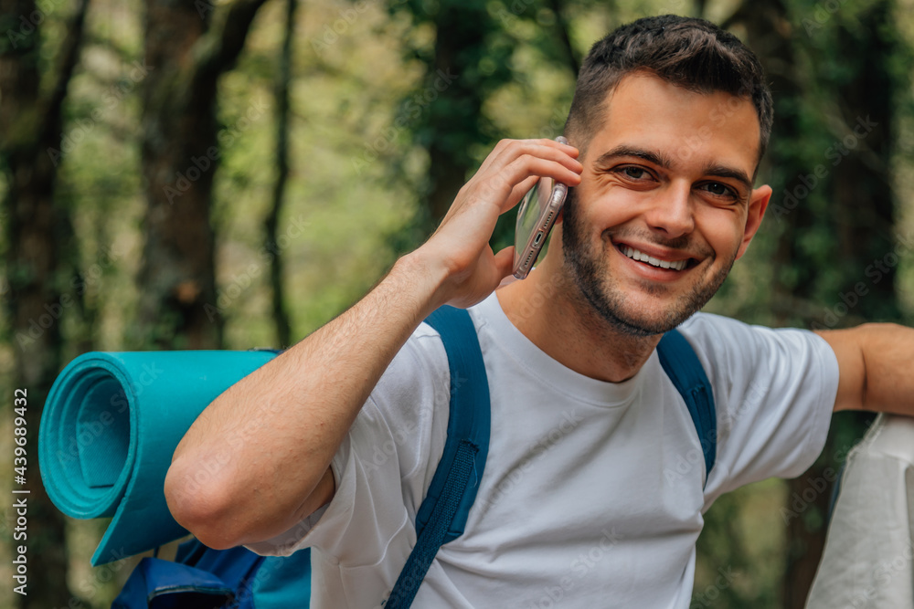 portrait of young man with backpack on travel talking on mobile phone portrait of young man with backpack on travel talking on mobile phone