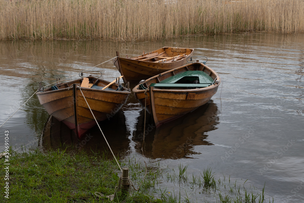 Three row boats bob in the water. Three row boats bob in the water.