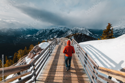 A man with a red jacket looking at the Canadian Rockie mountains in Banff, Canada photo