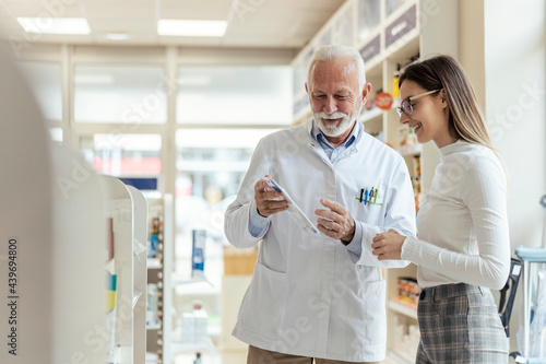 Consultation with a professional, conversation between the pharmacist and the client. A mature man explains drug therapy to a client. An experienced pharmacist recommends therapy to the client